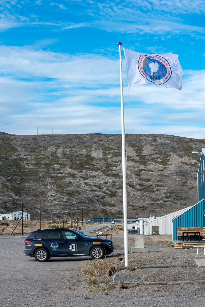 The KISS flag flies beside one of the Extreme E company cars.