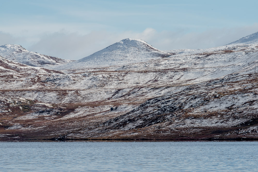 Lake Ferguson and a briefly spotlit snow-covered mountain to the south.